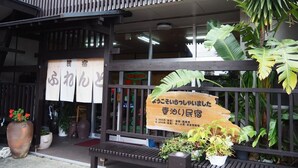 Un restaurante con fachada de madera y letreros en japonés.
