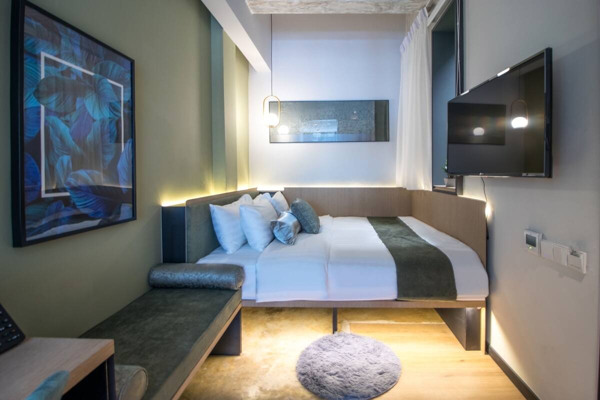 Une chambre à coucher moderne avec un lit, une table de chevet et une œuvre d’art accrochée au mur.