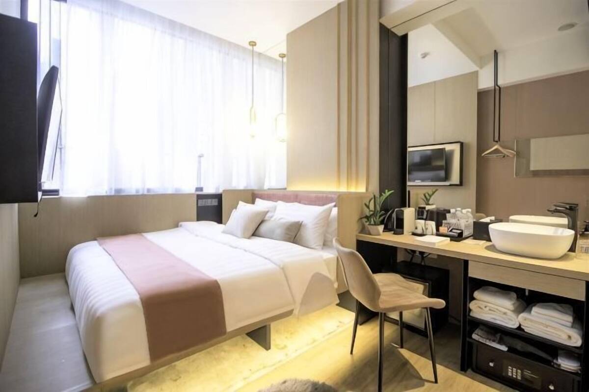 Une chambre d’hôtel moderne équipée d’un lit, d’un bureau et d’une salle de bain.
