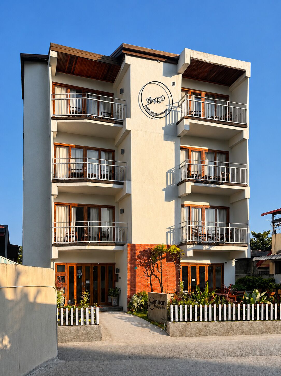 A multi-story hotel with balconies, a brick facade, and a sign indicating it is a hotel.