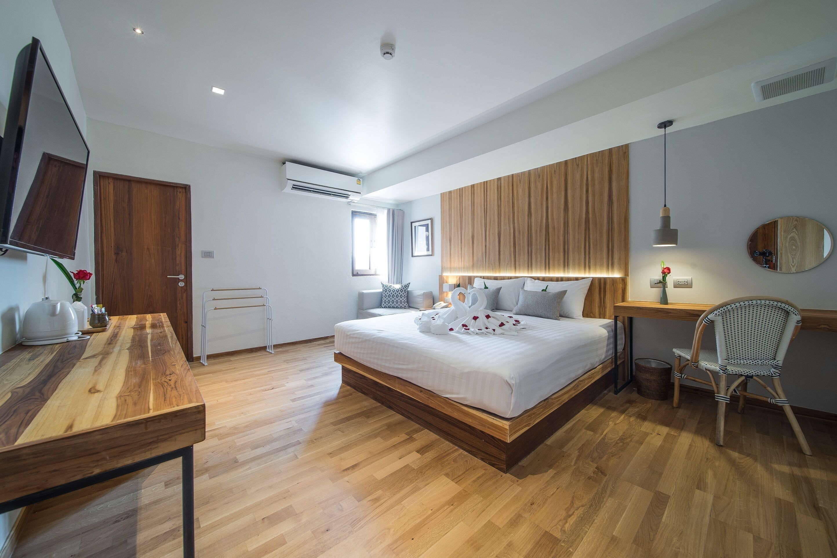 A modern bedroom with a wooden bed, a desk, and a chair.
