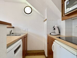 A compact kitchen with a microwave, a coffee maker, and a dishwasher.