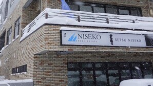 Un bâtiment sur lequel on peut lire les inscriptions « NISEKO Immobilier » et « SETSU NISEKO ».