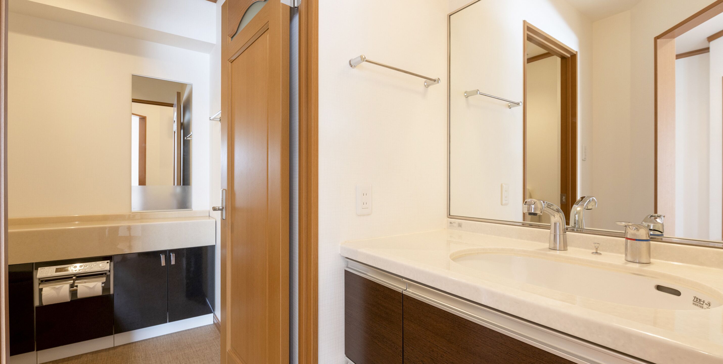 Un baño moderno con lavamanos doble, un espejo y un perchero para toallas.