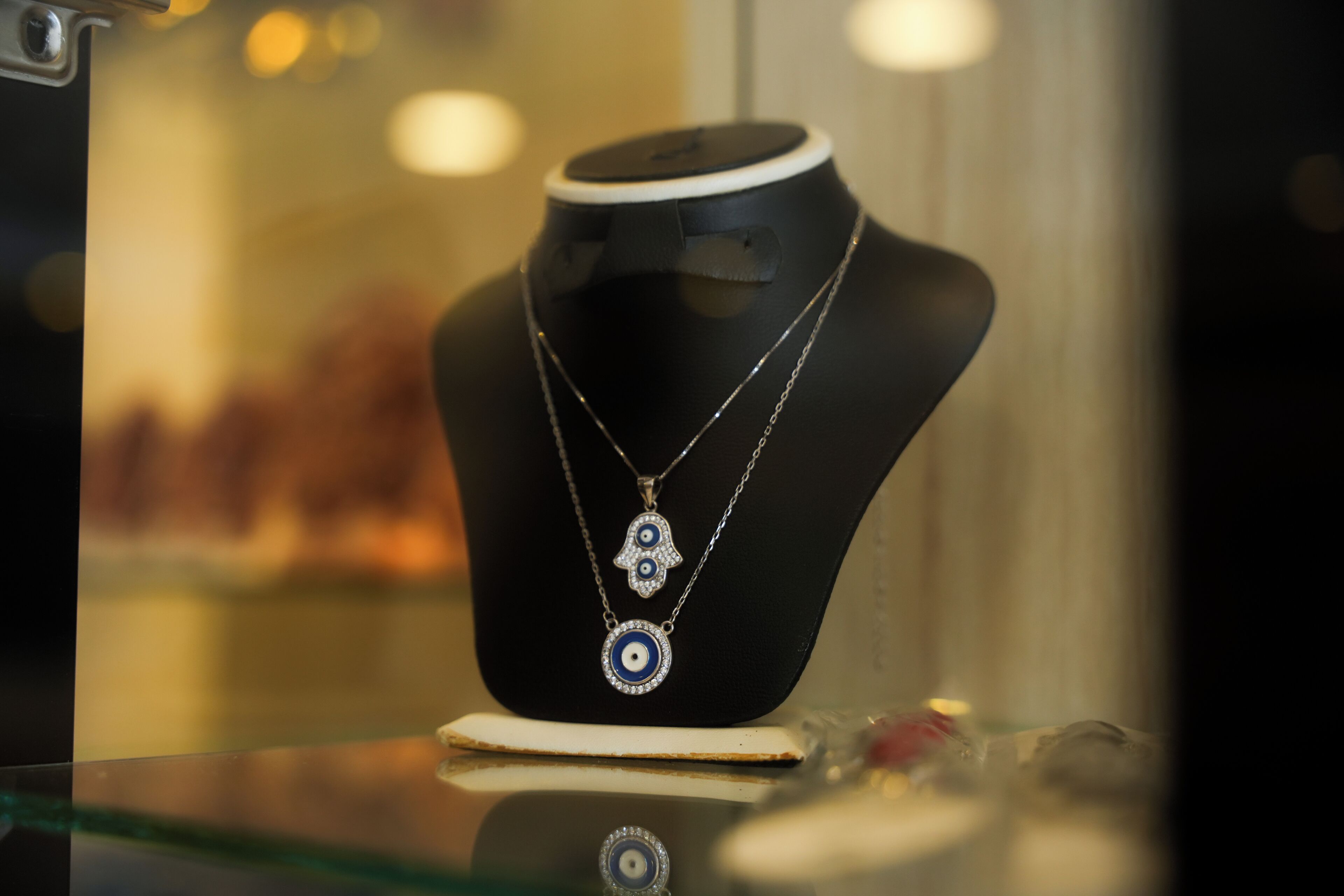 A jewelry display with a black mannequin bust and a glass counter.