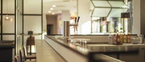 Zona de bar con una barra larga, asientos y diseño interior moderno.