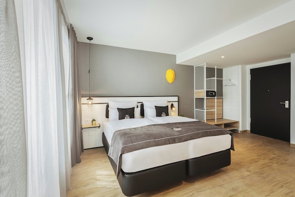 Un dormitorio moderno con cama, mesitas de noche, lámpara colgante, armario empotrado y una puerta.
