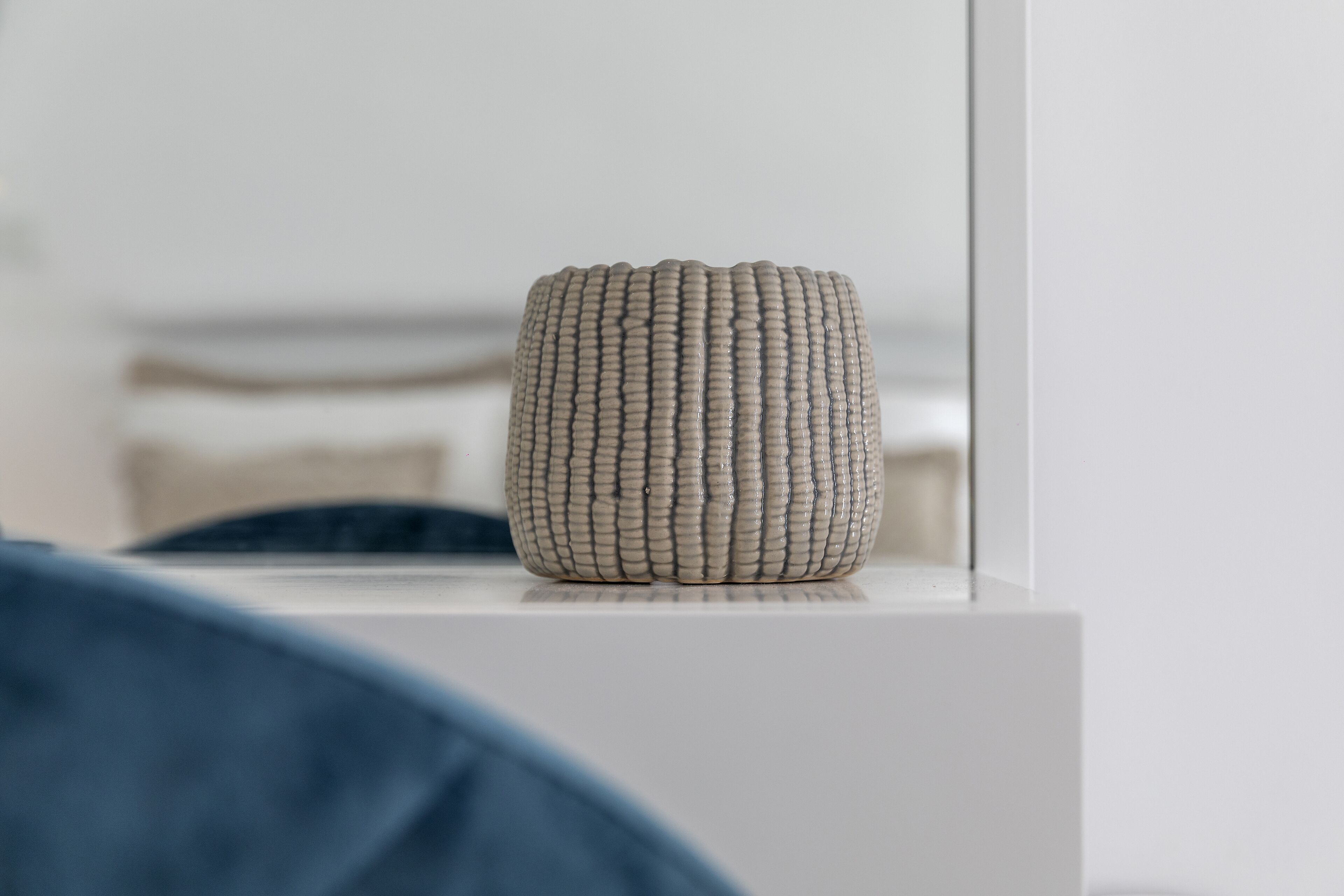 A cylindrical object with a textured surface, placed on a white surface.