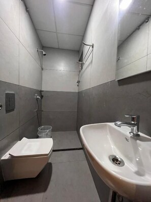 Un bagno piccolo e moderno con lavandino, specchio e doccia.