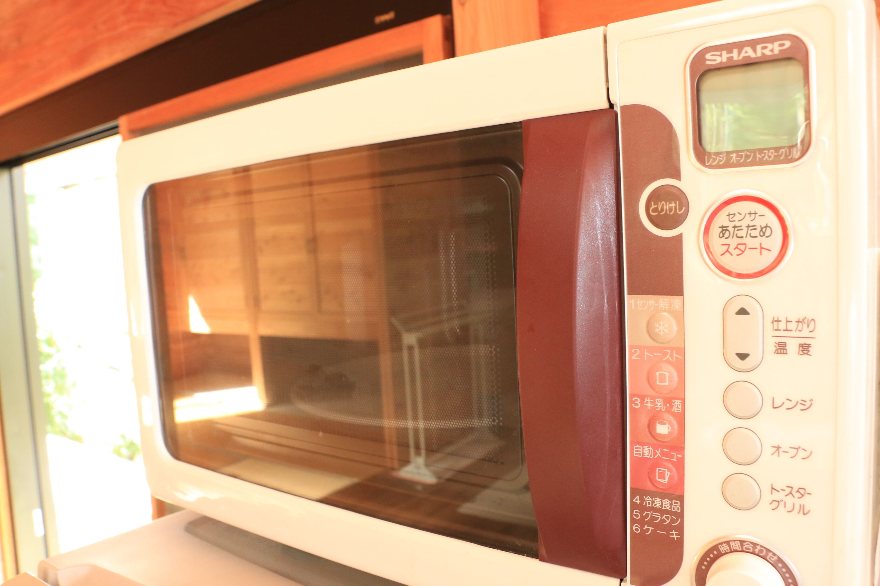 A microwave oven with Japanese labels and a digital display.