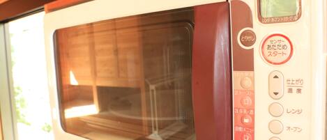 A microwave oven with Japanese labels and a digital display.
