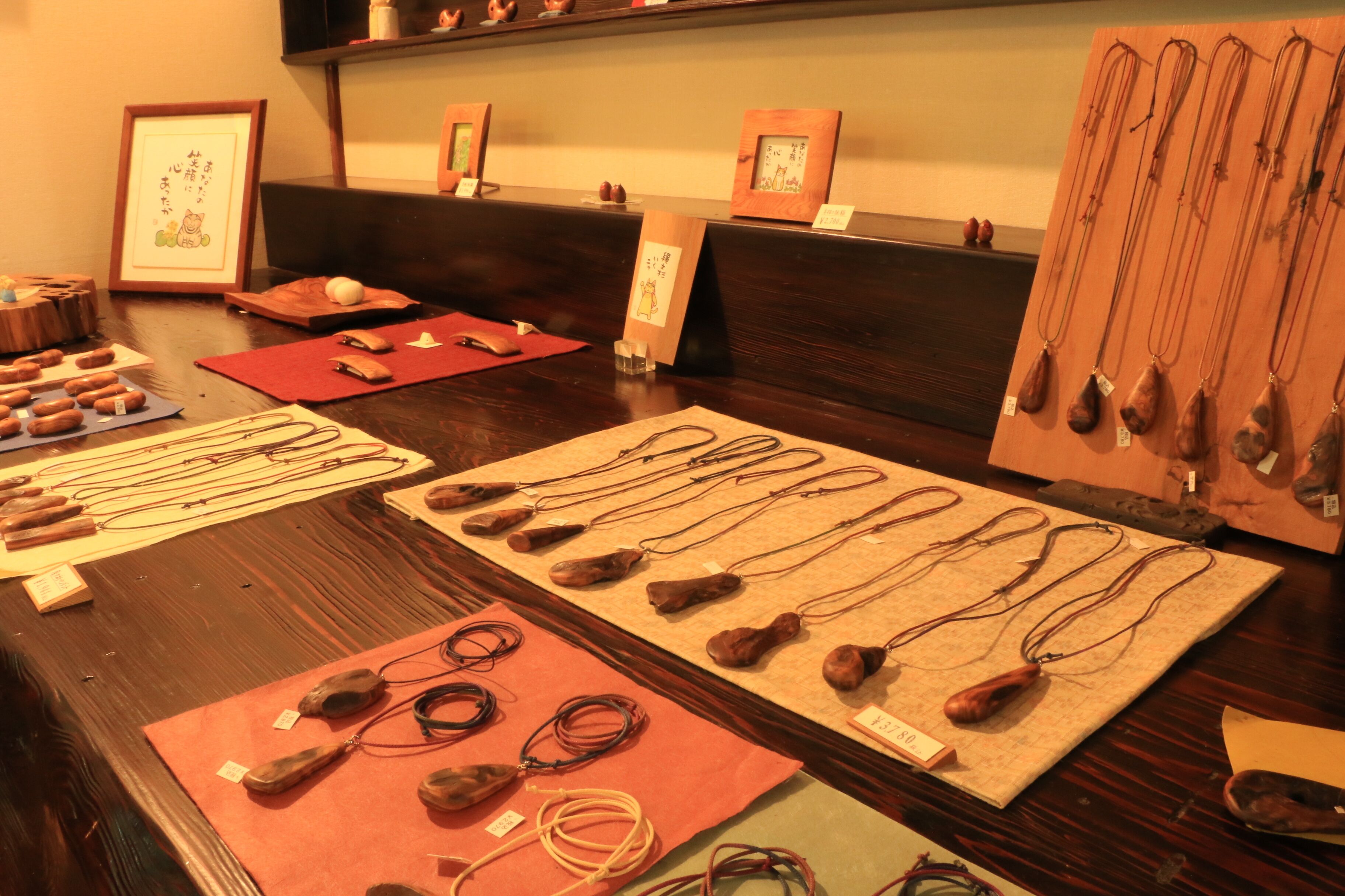 Una exhibición de diversos objetos tradicionales japoneses, como tallados de madera y hilos, dispuestos sobre una mesa.