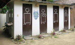 A row of doors with simple line drawings of people, a decorative owl, and a sun symbol. - Paglaom Hostel - Adults Only (General Luna)