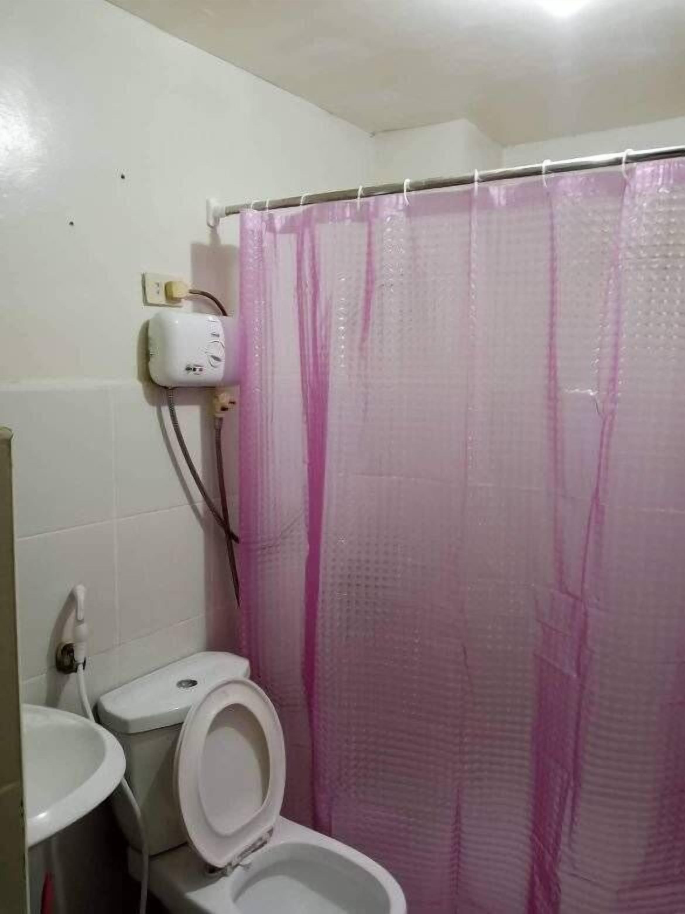 Ein Badezimmer mit Toilette, Waschbecken und Duschvorhang.