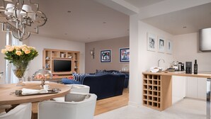 Una sala de estar moderna con televisor, sofá y comedor.