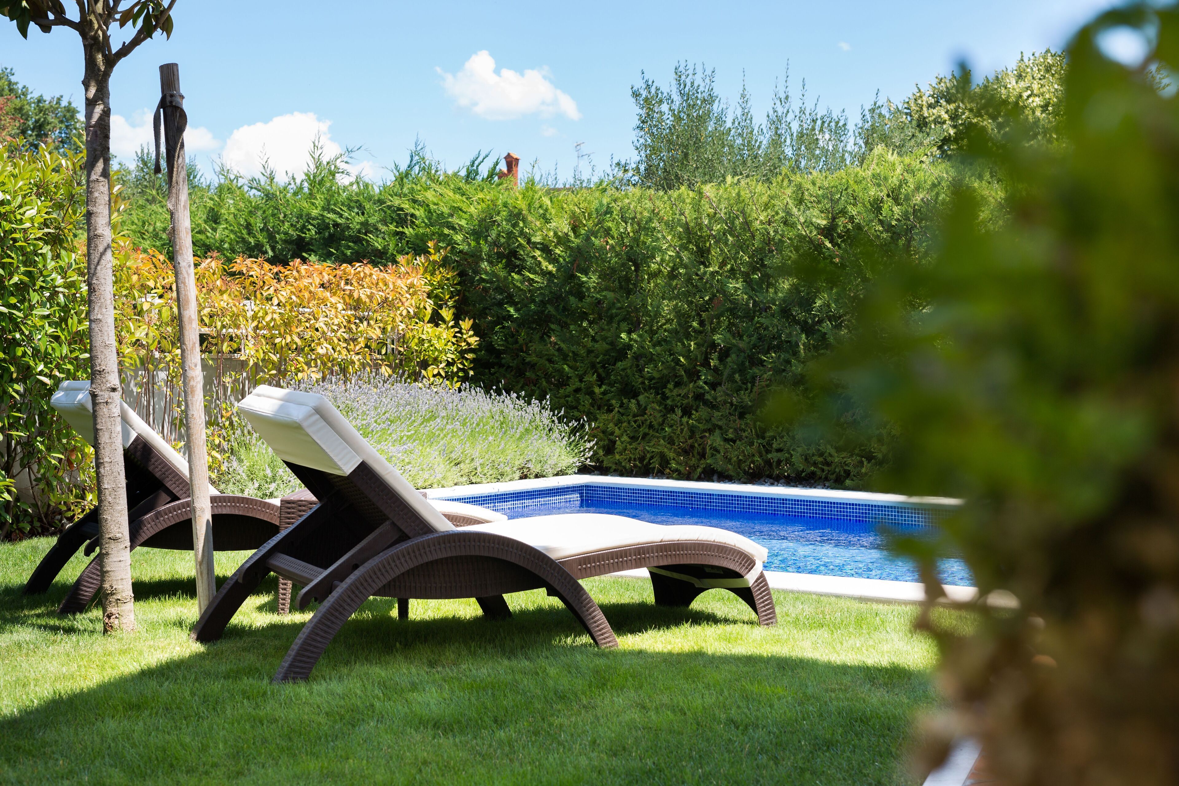 A poolside area with two lounge chairs and a small pool.
