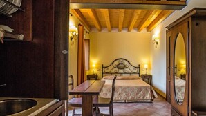 Une chambre à coucher comprenant un lit, des tables de chevet, une chaise en bois et une armoire en bois.