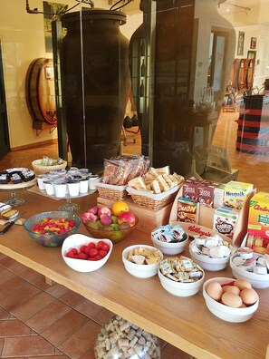 Een buffet met diverse soorten eten, waaronder fruit, brood en portiehapjes.