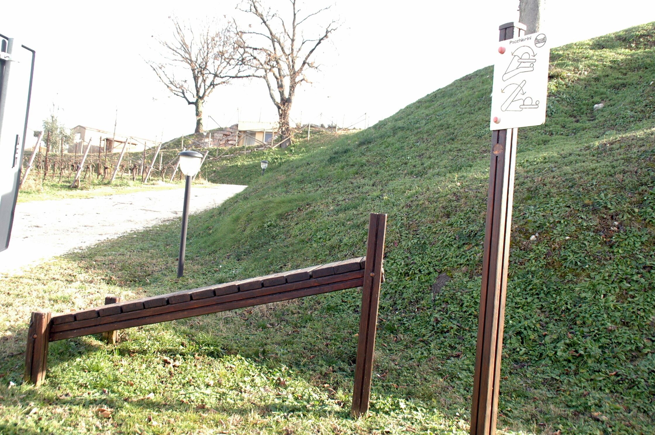 A wooden bench and a signpost with a pictogram.