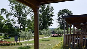 Une terrasse en bois offrant une vue sur un jardin et un belvédère.