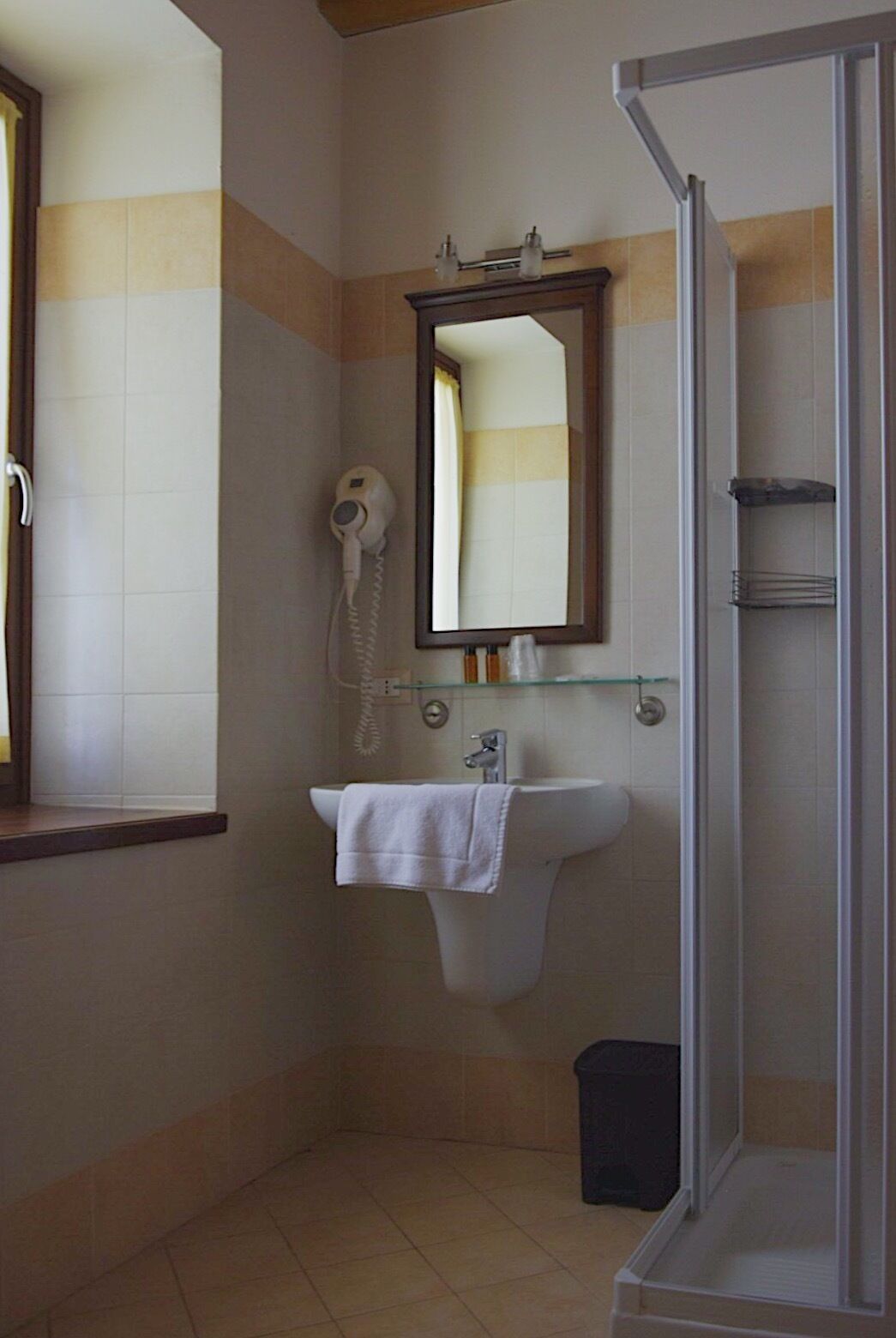 Casa de banho com lavatório, espelho e secador de cabelo.