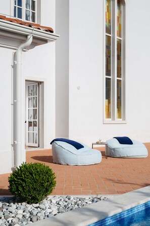 A poolside area with two light blue cushioned chairs, a small table, and a potted plant. - Villa Cesara (Tar-Vabriga)
