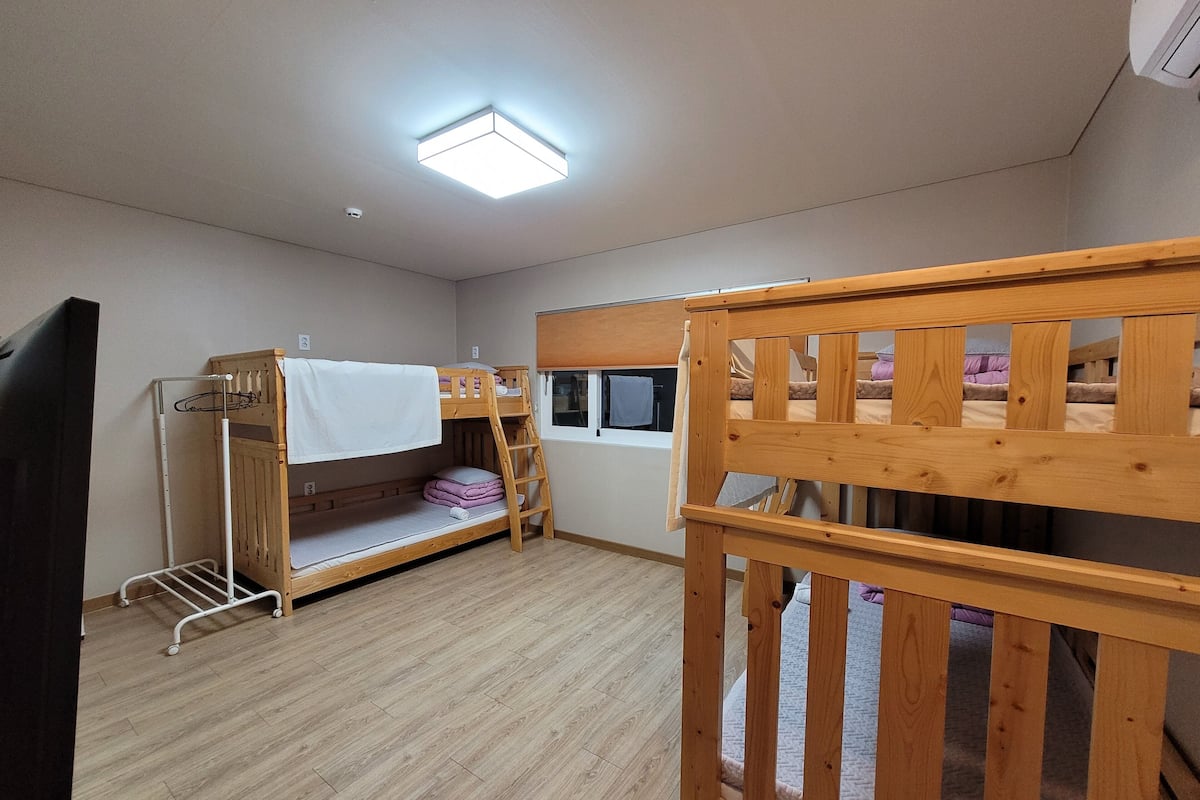 Una habitación con dos literas, una ventana pequeña y una lámpara en el techo.