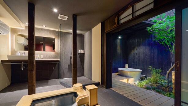 Ein modernes Spa mit Whirlpool, Holzterrasse und Blick auf einen Garten.