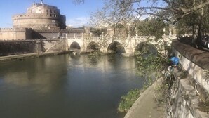 A historic building with a round tower and a bridge over a river. - Lungotevere Collection Suite (Rome)