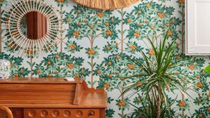 A room with a wooden desk, a woven mirror, and a potted plant. - Balate Dimora In Centro (Ragusa)