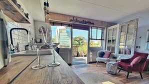 Cocina moderna con encimera de madera, copas de vino y vistas al exterior.