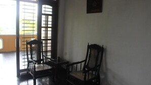 A room with a traditional Japanese sliding door, a wooden chair, and a small table. - Gerard Holiday Home (Kandy)