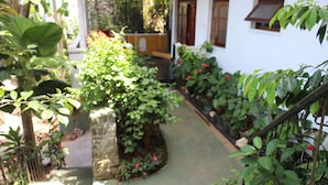 A narrow pathway leading to a white building with a small garden area. - Gerard Holiday Home (Kandy)