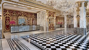 A luxurious lobby with ornate gold detailing, a checkered floor, and a grand chandelier. - Hotel Alexandra (Hong Kong)