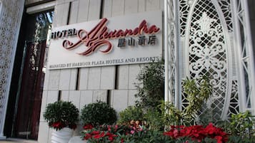 Et hotelskilt med navnet "Hotel Alexandra" og en dekorativ metalport.