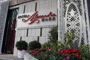Un letrero de hotel con el nombre 'Hotel Alexandra' y una ornamentada reja metálica.