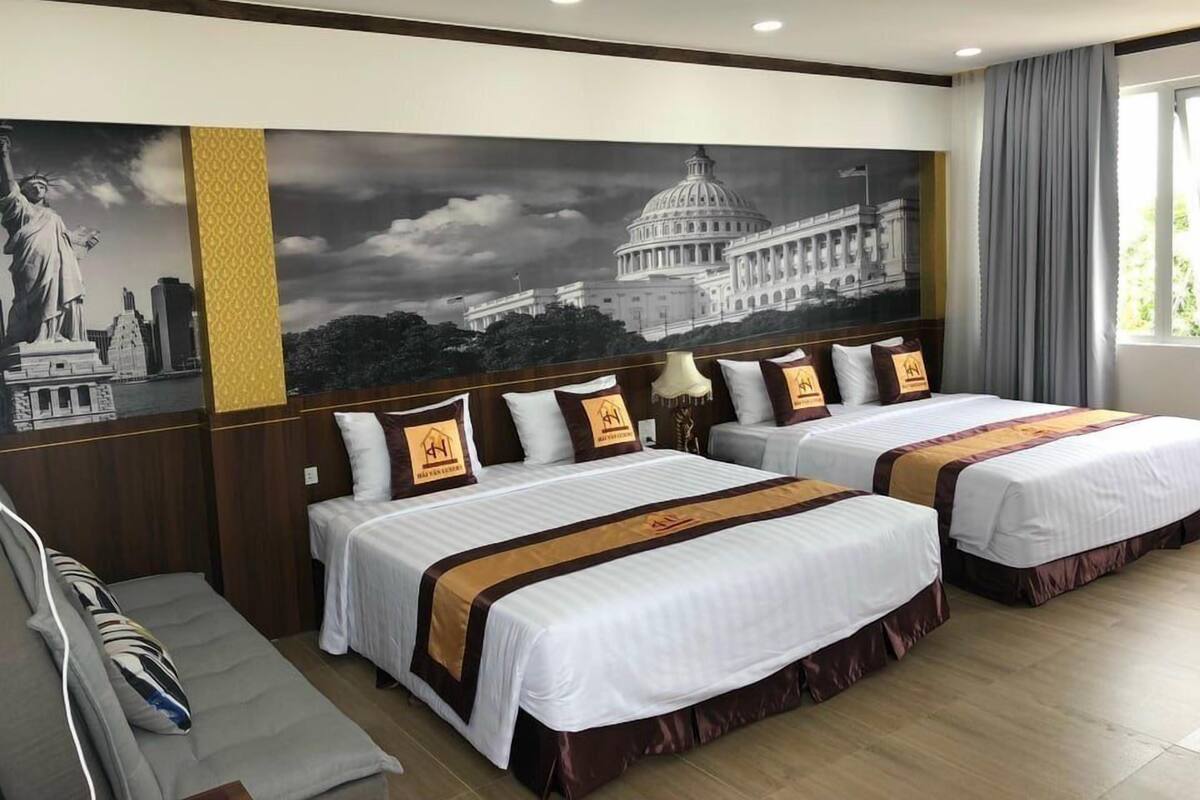 A hotel room with two beds, a large wall mural, and a view of the Capitol building.