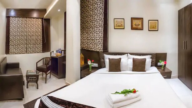 A modern bedroom with a large bed, a desk, and a chair. - Hotel Imperial (Ajmer)