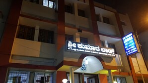 A multi-story building with a signboard for a hotel named "Sri Konda Lodge Deluxe AC - Non AC Rooms". - Sri Kumara Lodge (Bengaluru)
