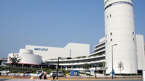 A modern building with a cylindrical tower and a flat-roofed section. - Tenjin Higashi Russo (Fukuoka)
