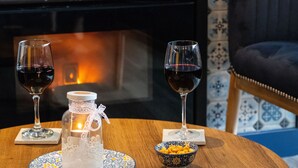 Una mesa con dos copas de vino, una vela y un recipiente con aperitivos.