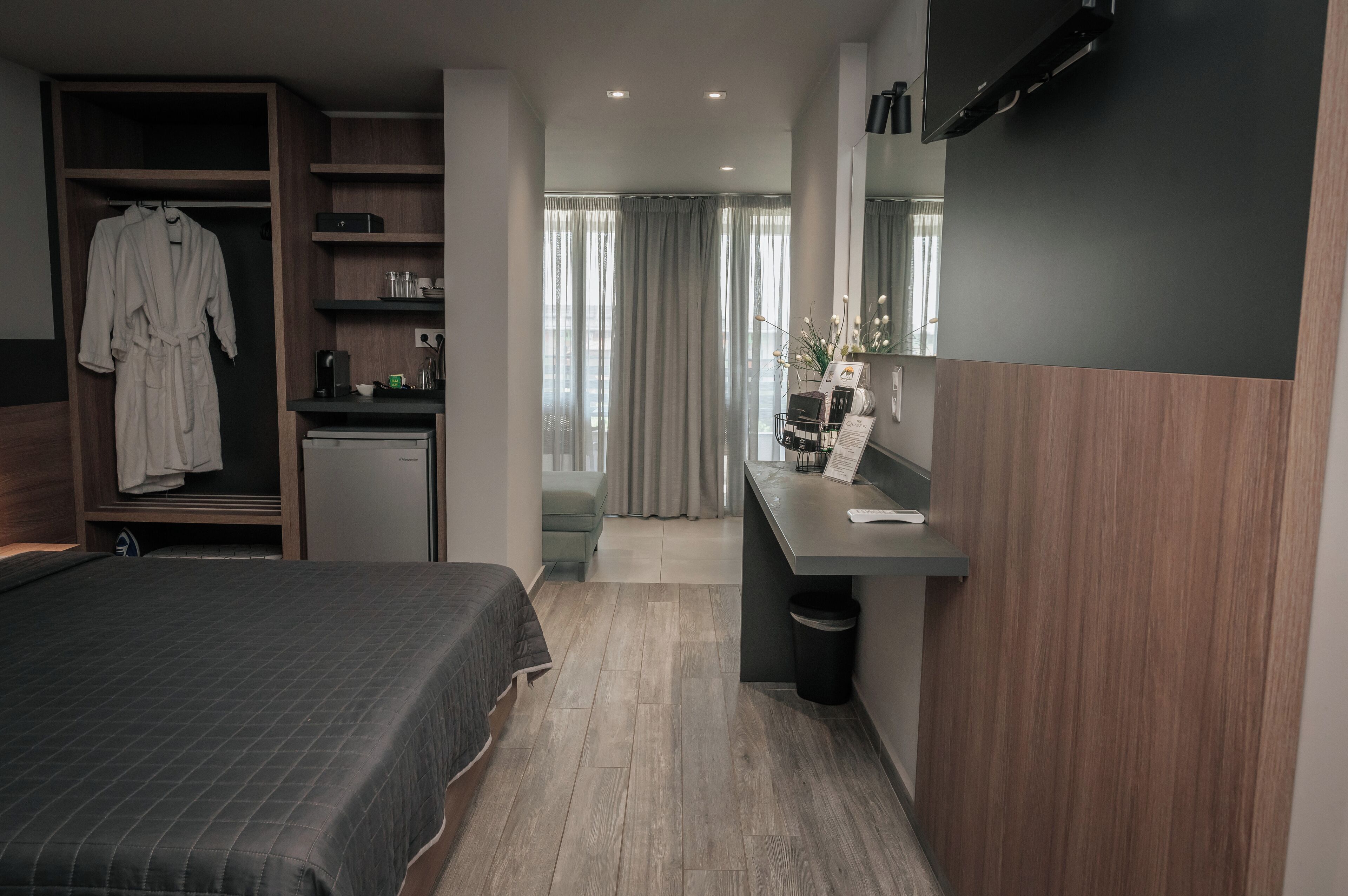 Una habitación de hotel moderna con cama, escritorio, armario y baño.