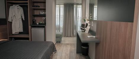 Una habitación de hotel moderna con cama, escritorio, armario y baño.