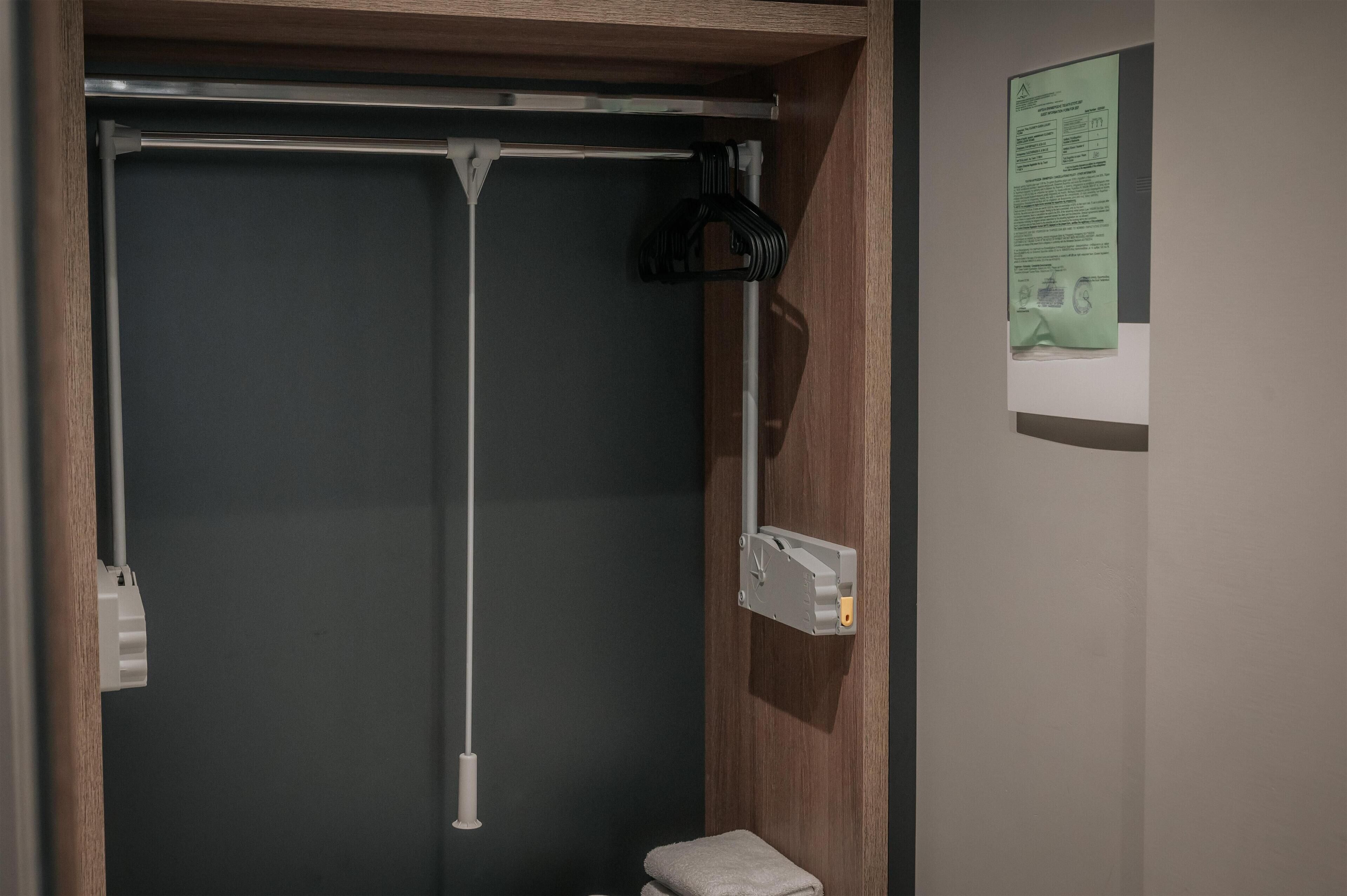 A bathroom with a shower, a towel rack, and a wall-mounted paper with text.