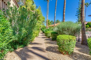 Stroll through lush gardens and approach the serene Mediterranean-style building with a terracotta roof.