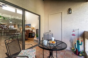 Enjoy a quiet moment on this patio with a round table and comfortable seating for two.