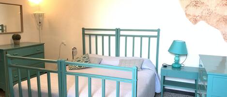 A bedroom with a bed, bedside tables, a lamp, a dresser, and a mirror.