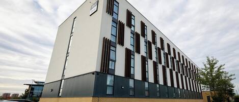 Un bâtiment moderne doté d’un toit plat, de grandes fenêtres et d’une base en briques.