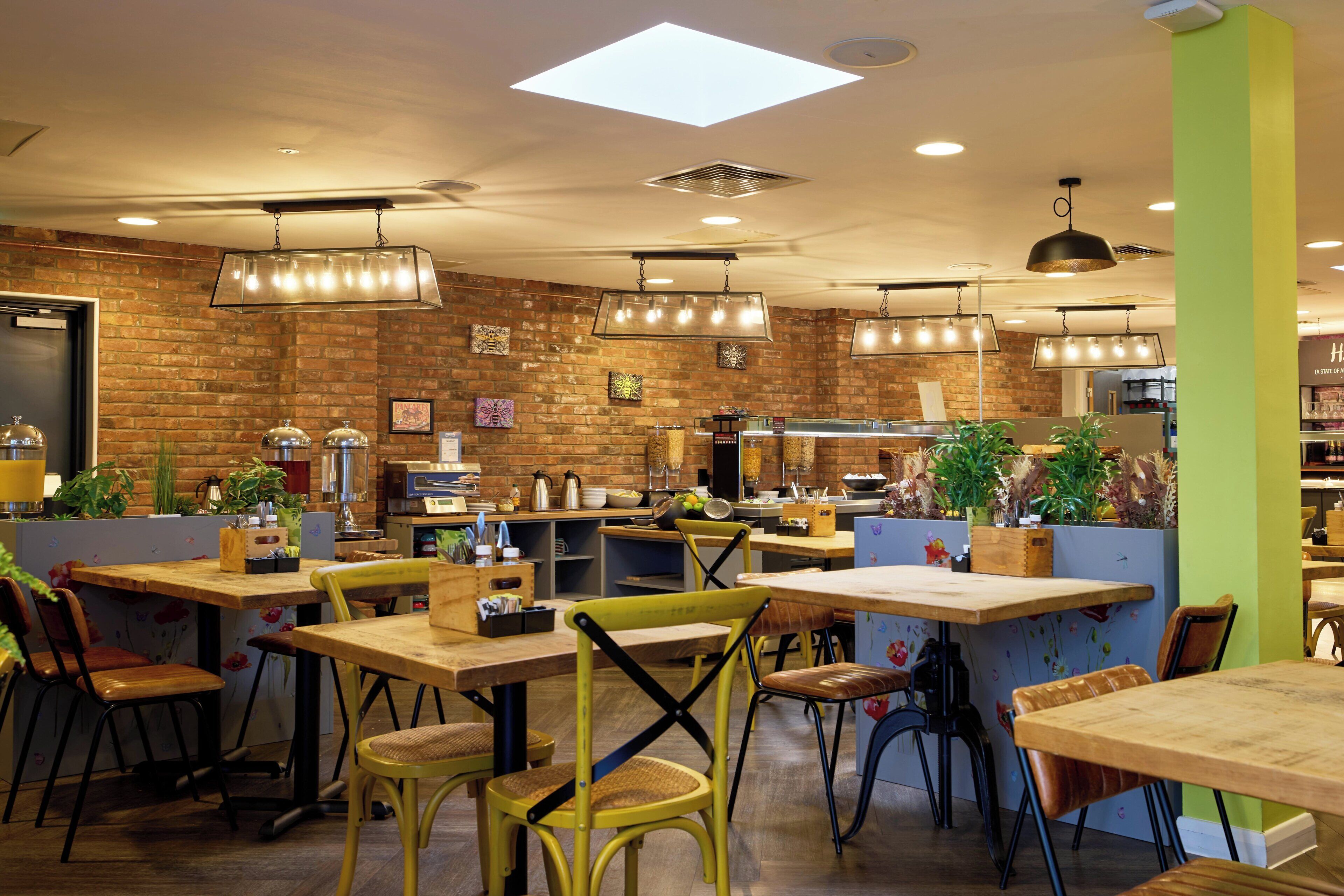 A restaurant with brick walls, wooden tables, and hanging lights.