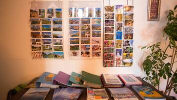 Eine Wand mit mehreren Fotoalben und ein Holztisch mit Büchern und Ordnern.